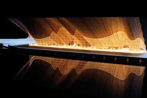  Die von ALA Architects entwickelte 3 500 m² große, geschwungene Wave-Wall aus Eichenbrettern ragt 35 m aus und wird durch eine vertikale Glaswand in Vordach und Foyer unterteilt 